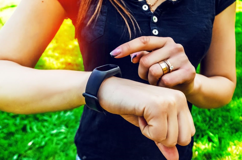 Imagem de uma mulher usando um smartwatch propício para a prática de exercício físico.