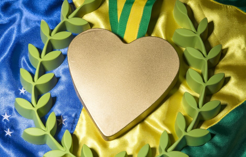 Imagem de uma medalha dourada sobre uma bandeira do Brasil.