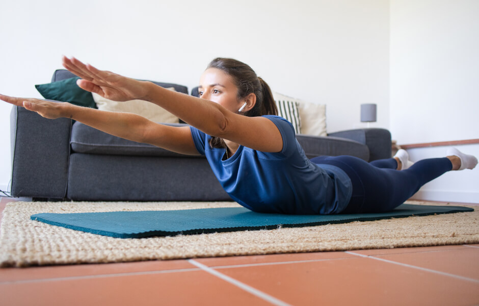 Foto de uma mulher executando o exercício "super-homem".