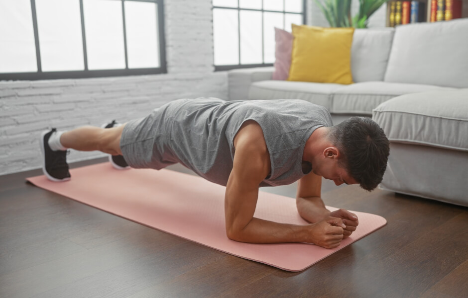 Foto de um homem executando o exercício "prancha frontal".