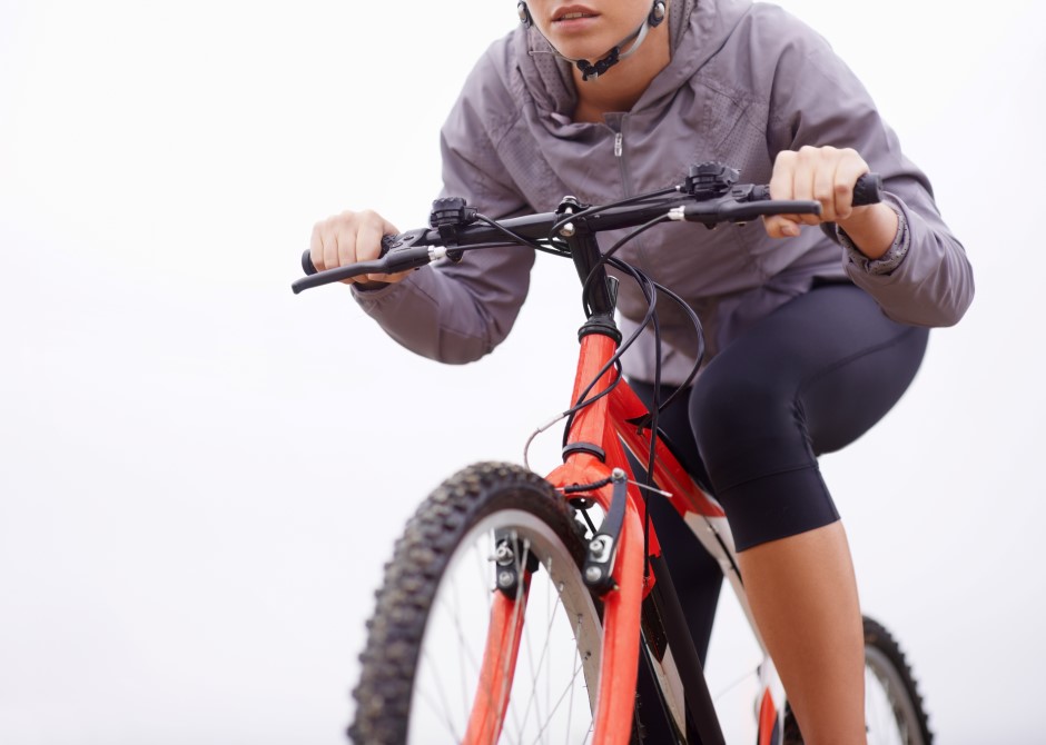 Mulher andando de bicicleta com traje adequado de ciclismo, fundo da imagem branco