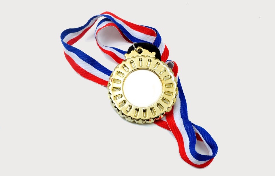 Imagem de uma medalha dourada com o contorno em formato de roda.