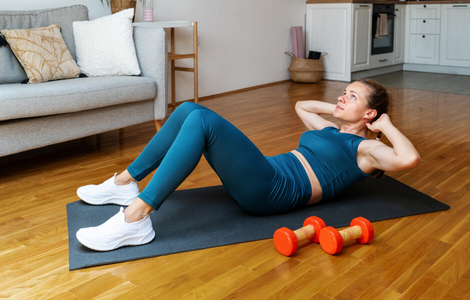 Foto de uma mulher executando o movimento "abdominal supra".