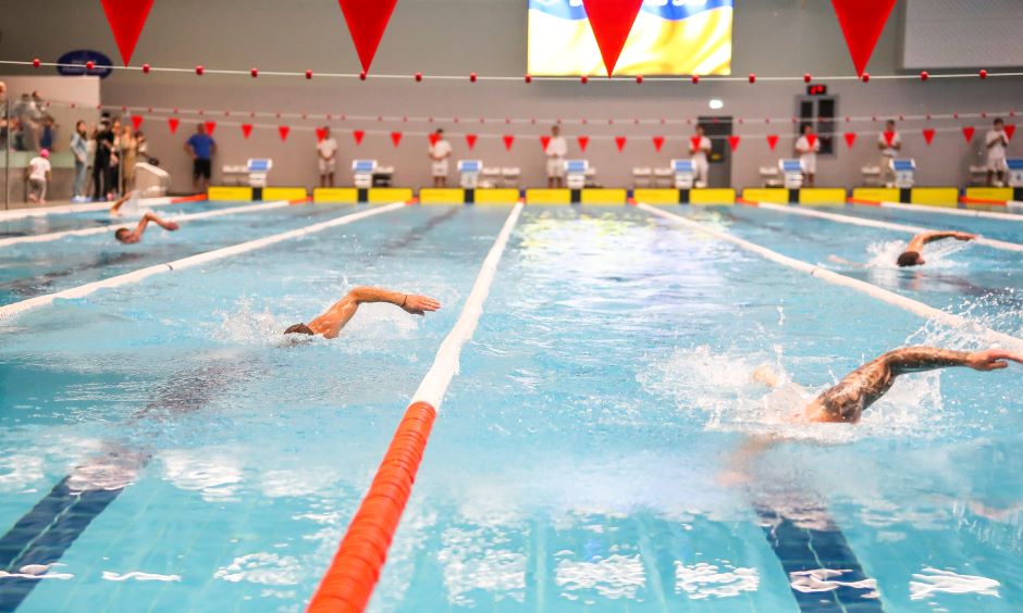 Alguns atletas de natação competindo em uma piscina  olímpica 
