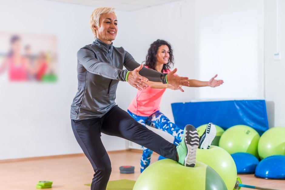 Dupla de mulheres fazendo exercícios com bolas de balancear 
